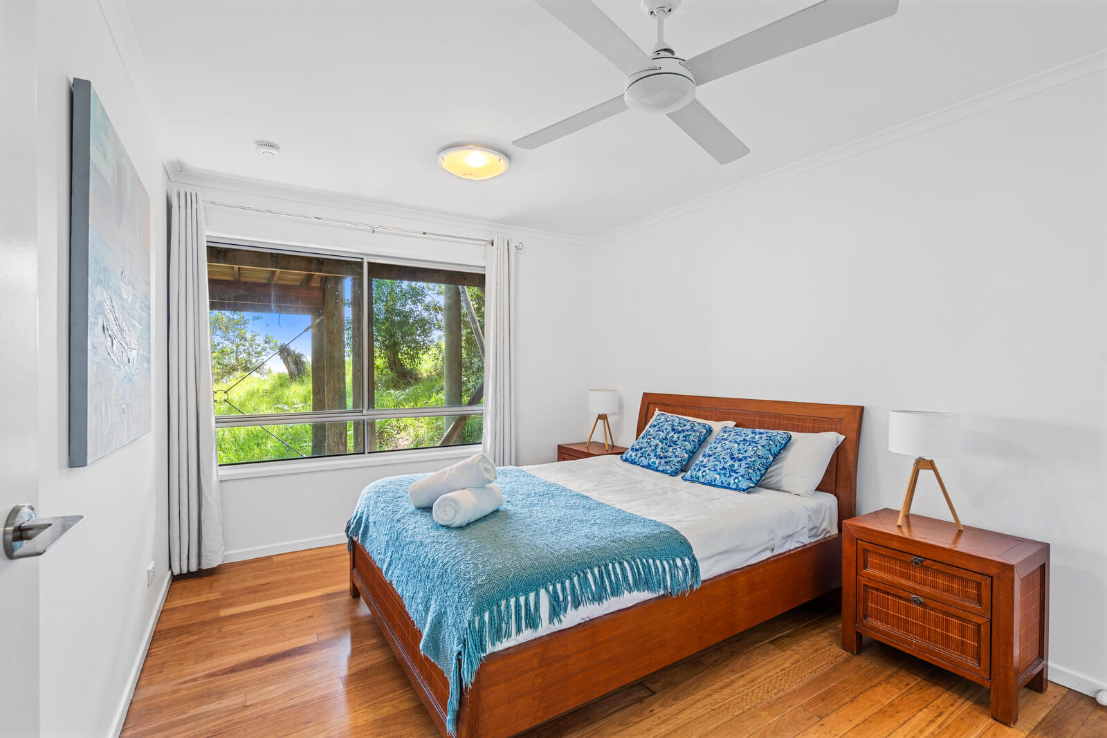 Main bedroom with queen bed and soft coastal styling