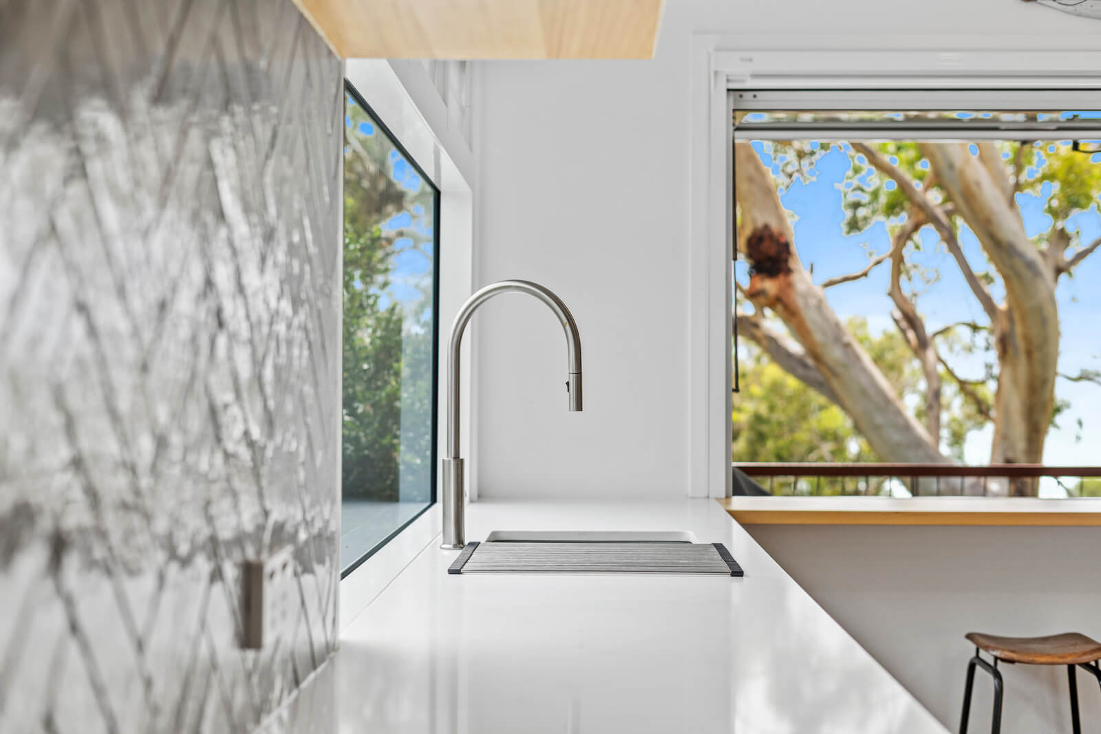 Surf Gums Sink faucet with coastal view through the window