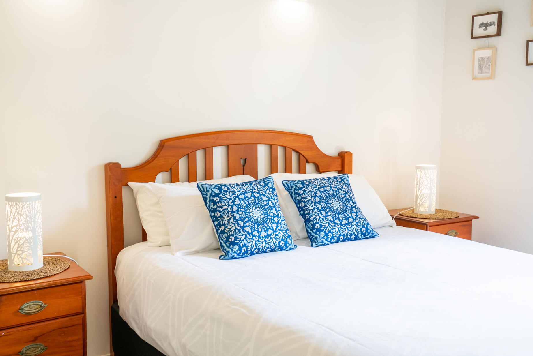 Bright bedroom with white bedding and blue pillows